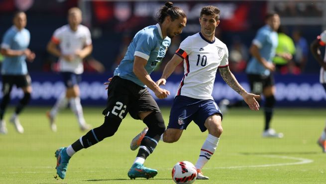 USMNT midfielder Christian Pulisic (#10) dribbles past Uruguay defender (#22) during the 0-0 international friendly at Children's Mercy Park on June 5, 2022