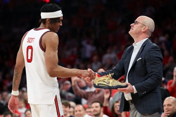 2/23/25 NY,NY MSG| Uconn coach Hurly returns Aaron Scott's sneaker to him on the sideline. Mandatory Credit: Bad Dawg Sports/Matthew Last