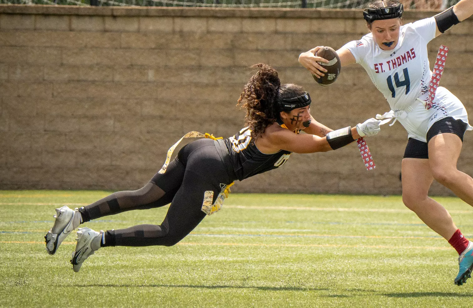 Two women playing collegiate flag football