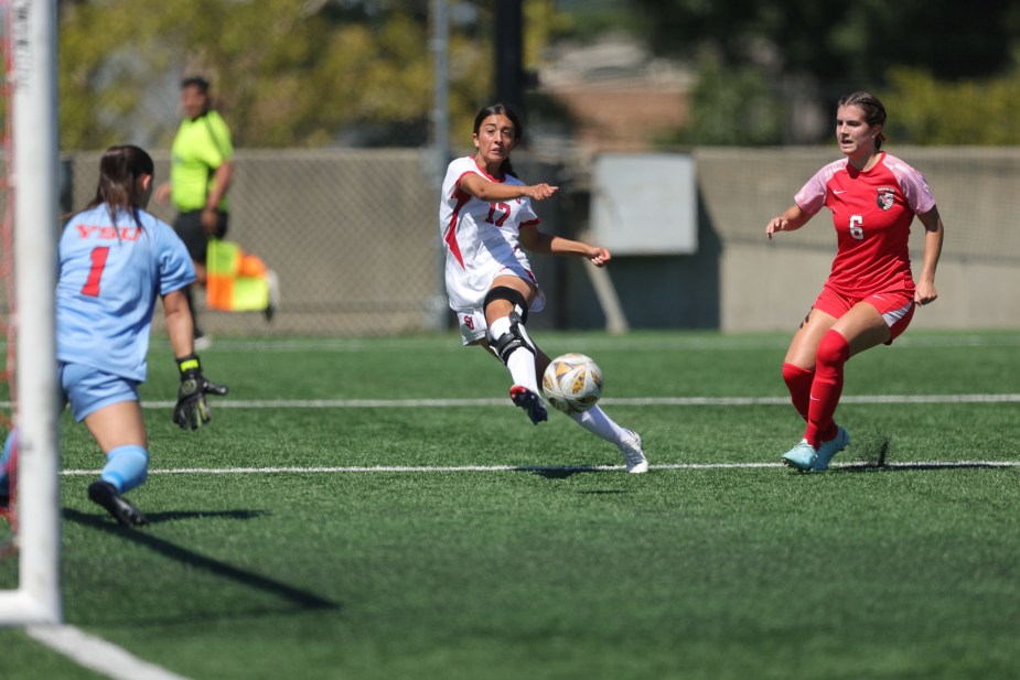 St. John's University freshman forward Leana Ruiz (#17) takes a shot on goal while being challenged by a Youngstown State defender during her first collegiate goal in the home opener