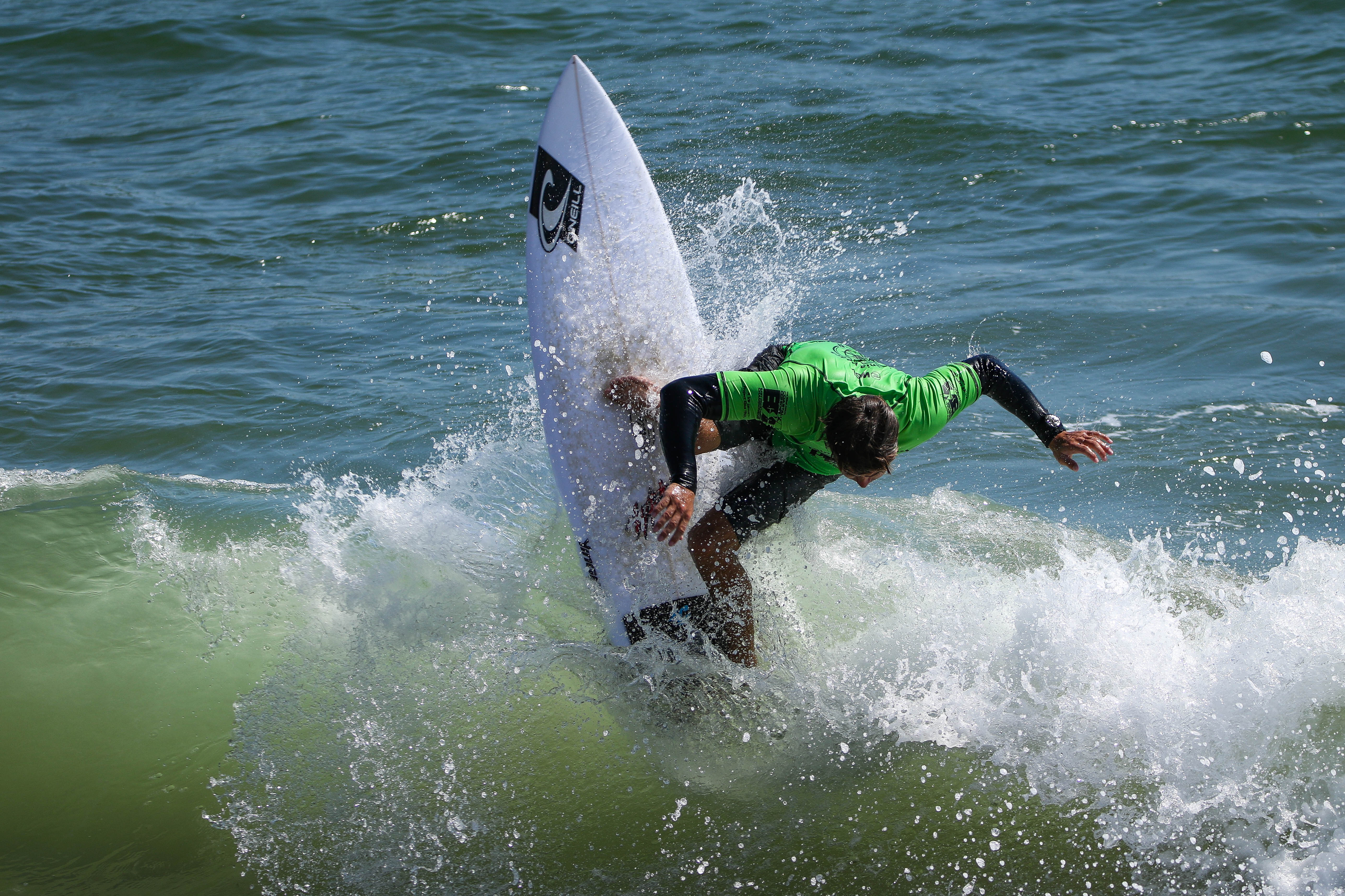 Blayr Barton executes aggressive cutback maneuver creating spray during 2024 Virginia Beach Pro surfing competition