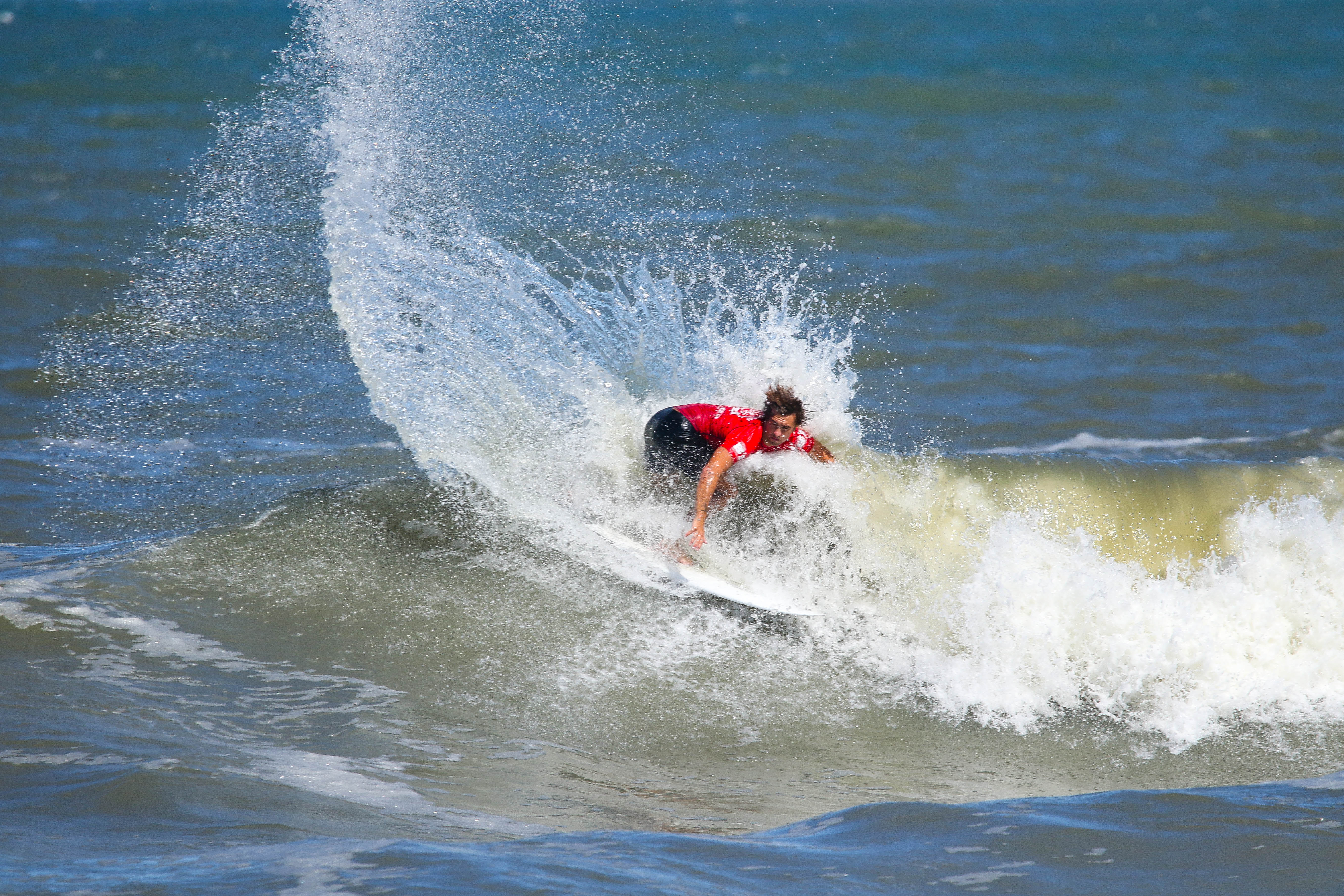 Defending champion Blayr Barton executes powerful backhand turn on wave at Virginia Beach Pro WSL competition in storm swell conditions