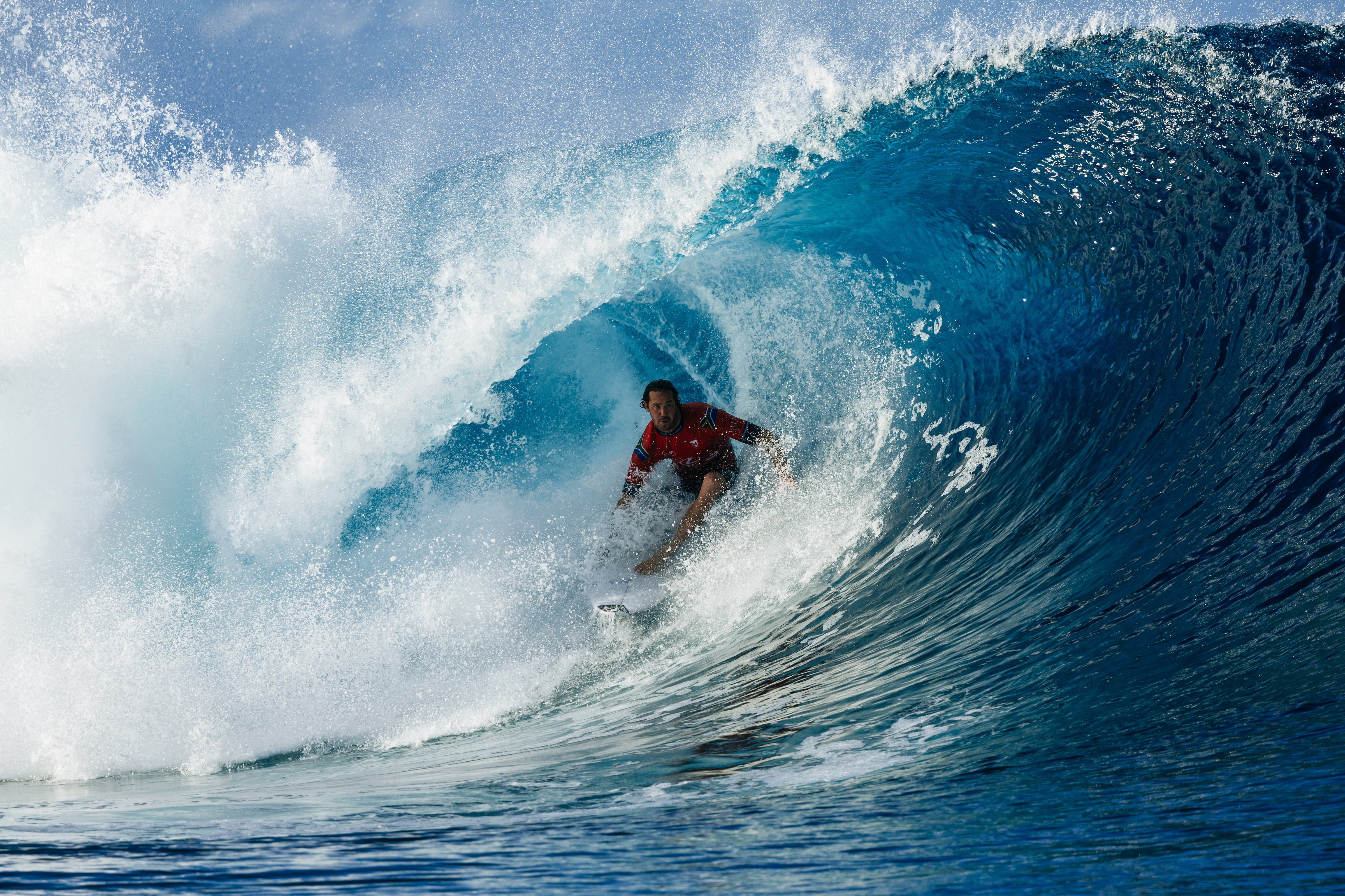 Jordy Smith surfs inside a perfect blue barrel at Teahupo'o during the 2025 Lexus Tahiti Pro WSL Championship Tour event