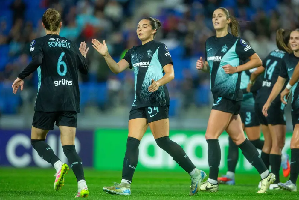 Gotham FC players celebrate together wearing dark teal jerseys with Emily Sonnett number 6 visible during 2-1 victory over CF Monterrey in Concacaf W Champions Cup