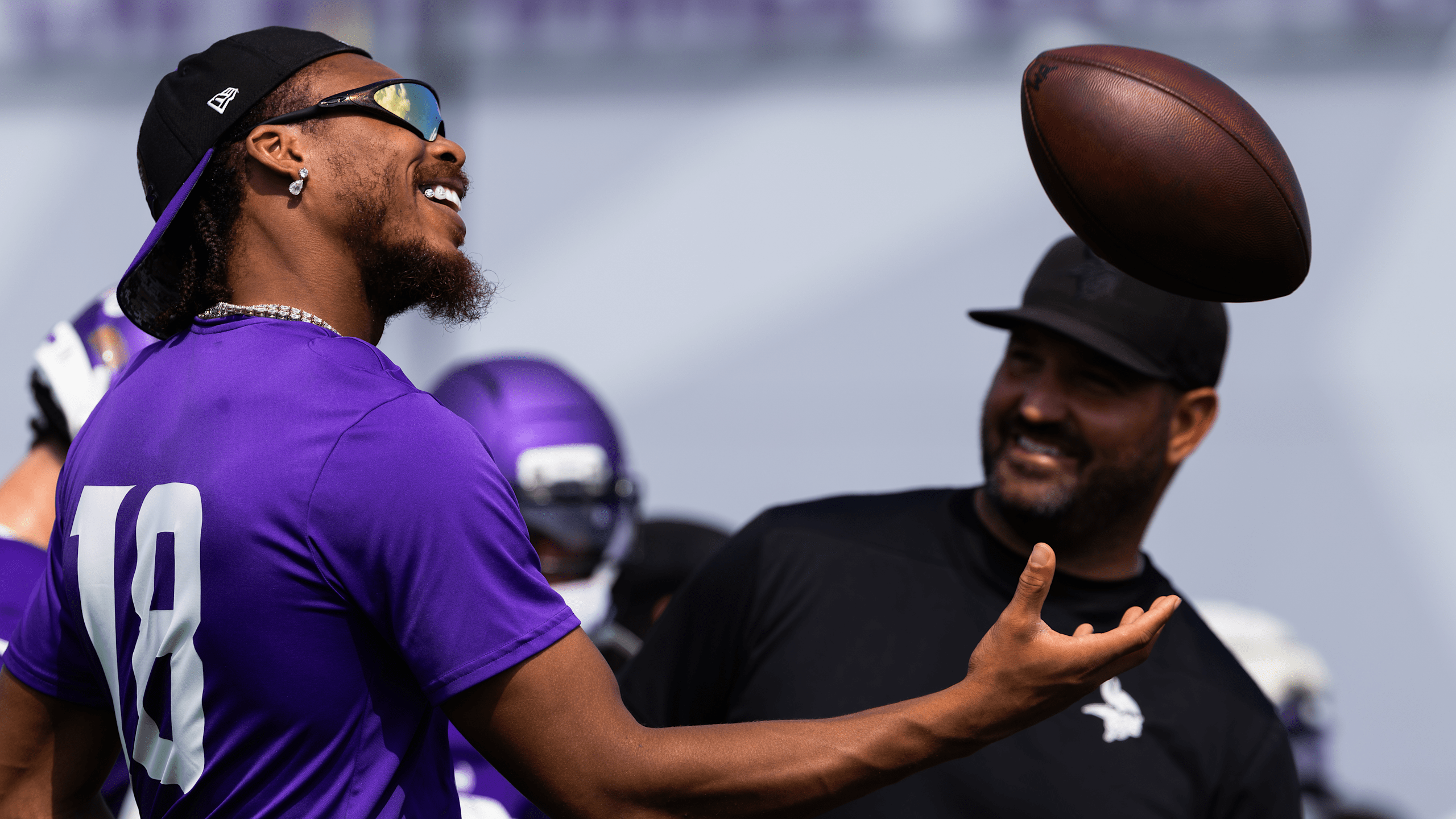 Justin Jefferson smiling and catching football during Minnesota Vikings training camp practice wearing purple jersey number 18