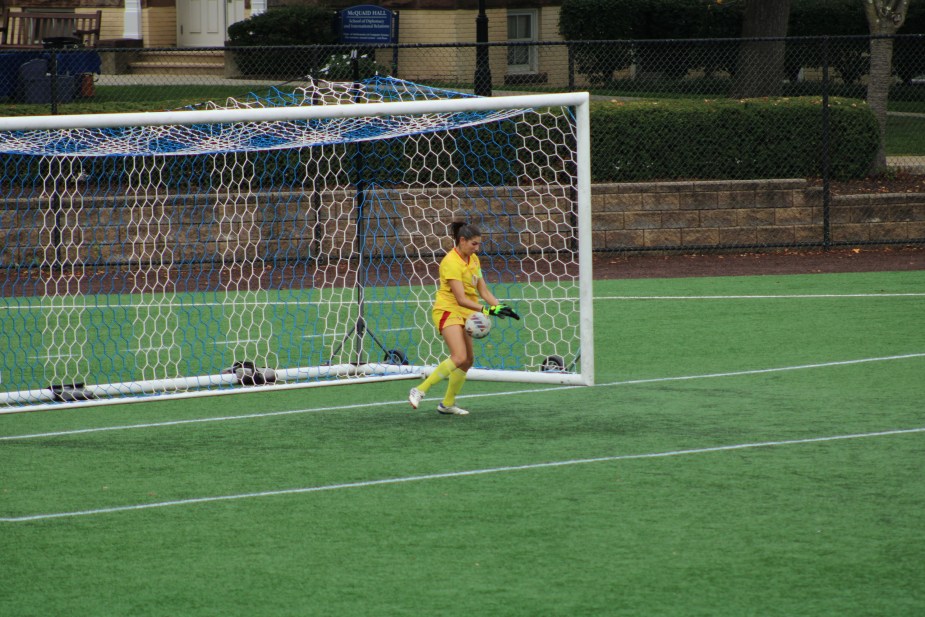 St. John's goalkeeper Kayla Bower in yellow uniform makes a save by catching the ball with both hands in front of the goal during first half action against Seton Hall