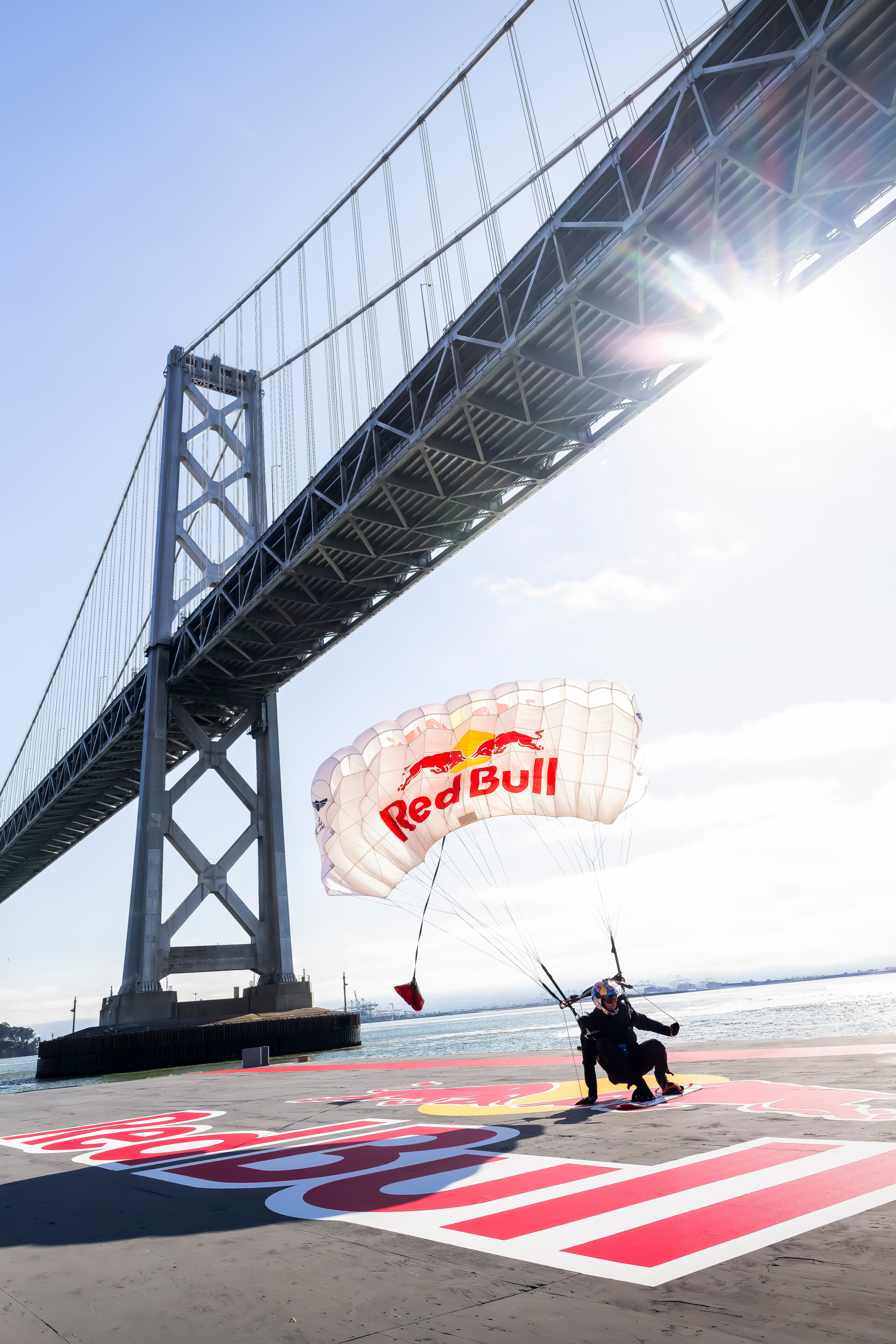 Sean MacCormac lands with Red Bull parachute on floating barge beneath San Francisco Bay Bridge after completing world-first cable skysurfing stunt