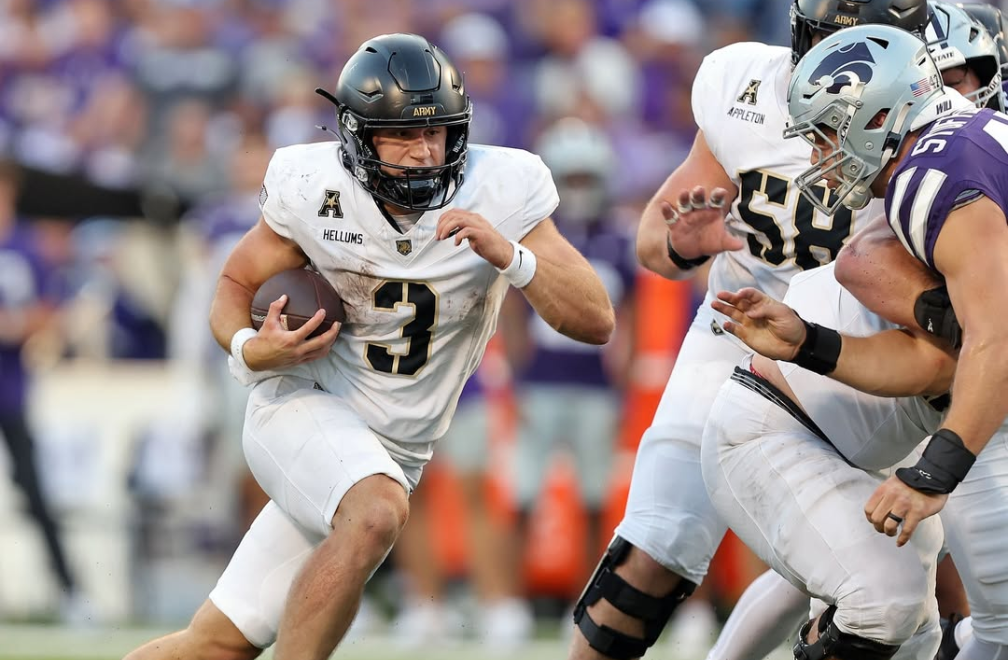 Cole Hellum in his White jersey with black and gold numbers and black helmet with the golden knight logo. He rushes for a large gain against Kansas State.