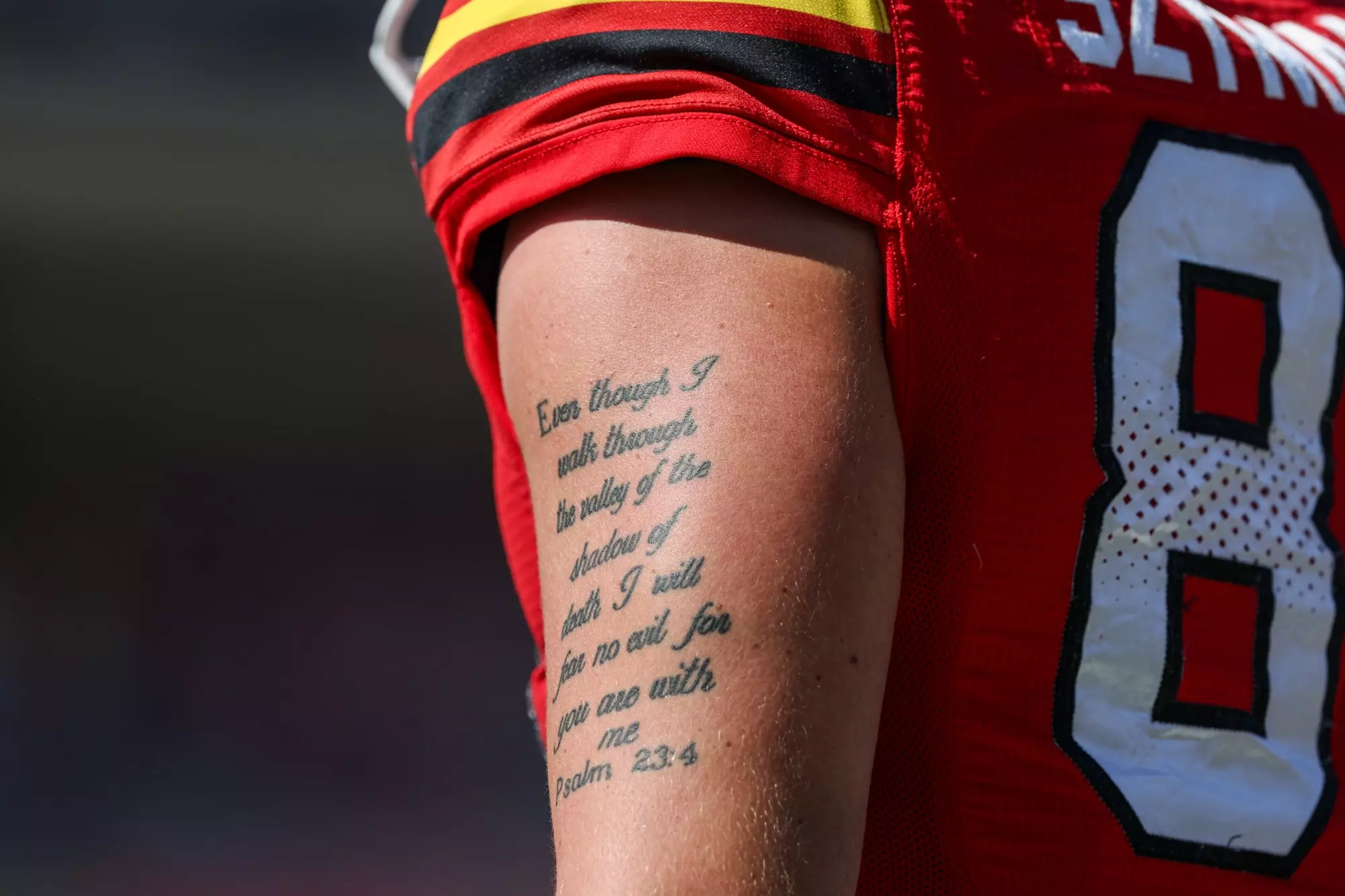 Close-up view of University of Maryland tight end AJ Szymanski's forearm tattoo displaying the biblical verse "Heavenly Father, even though I walk through the valley of the shadow of death, I will fear no evil, for You are with me" from Psalm 23:4