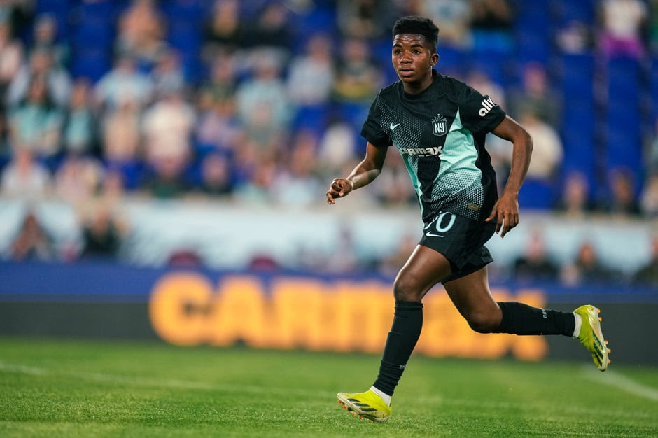 Gotham FC midfielder Stella Nyamekye running with the ball during a match, wearing the team's dark green jersey with number 20, showcasing her pace and technical ability