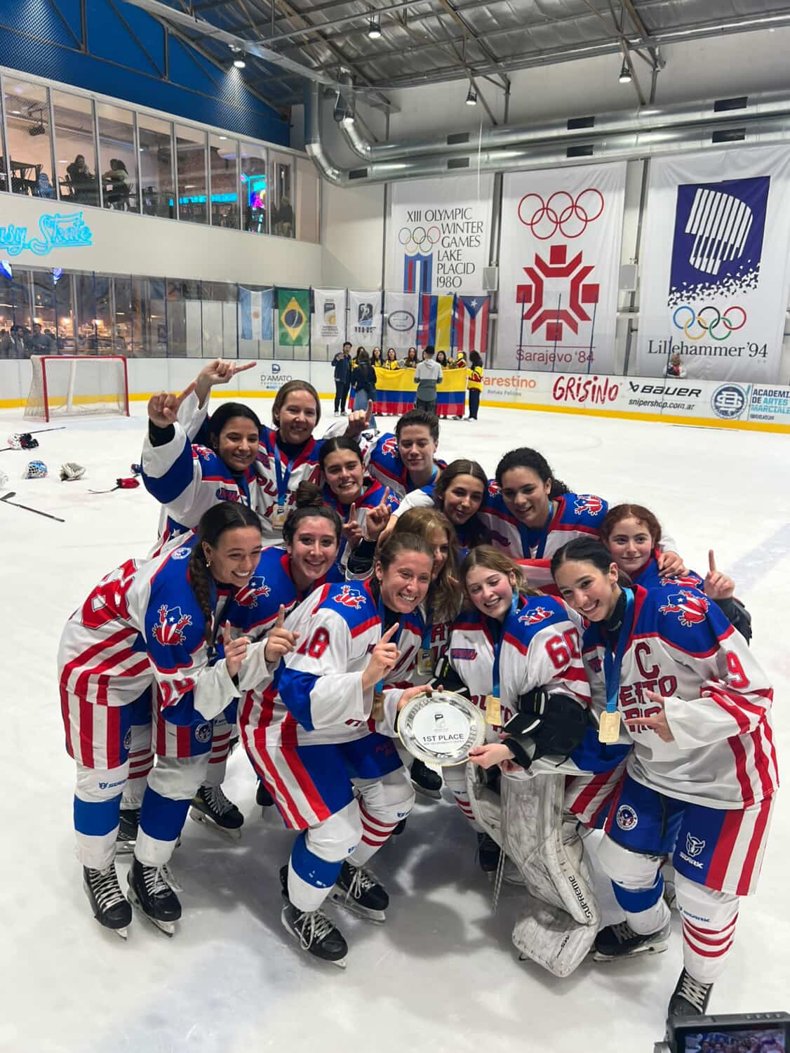 Puerto Rico women's hockey team celebrates with gold medals and the first-place trophy after defeating Argentina 7-6 in overtime to win the IIHF Women's Development Cup 3x3 championship at Fantasy Skate in Buenos Aires, Argentina, in November 2025