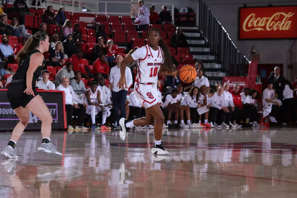 Brooke Moore dribbles at midcourt during St. John's women's basketball game, leading Red Storm offense in season opener