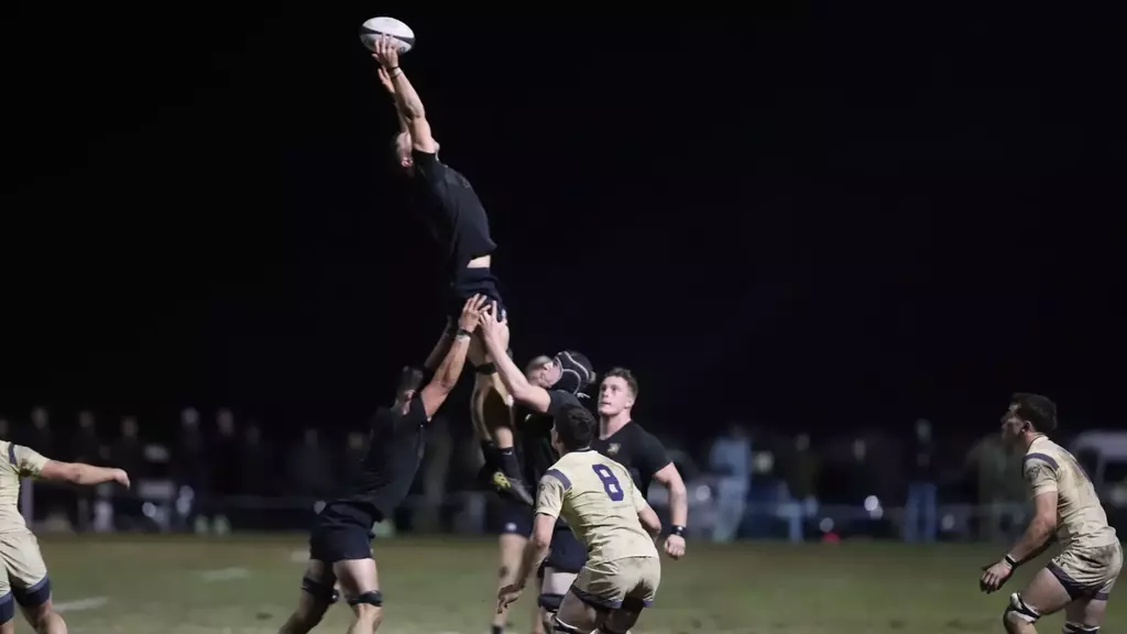 Army West Point rugby player in black uniform carries the ball during Star Series match against Navy at Anderson Rugby Complex