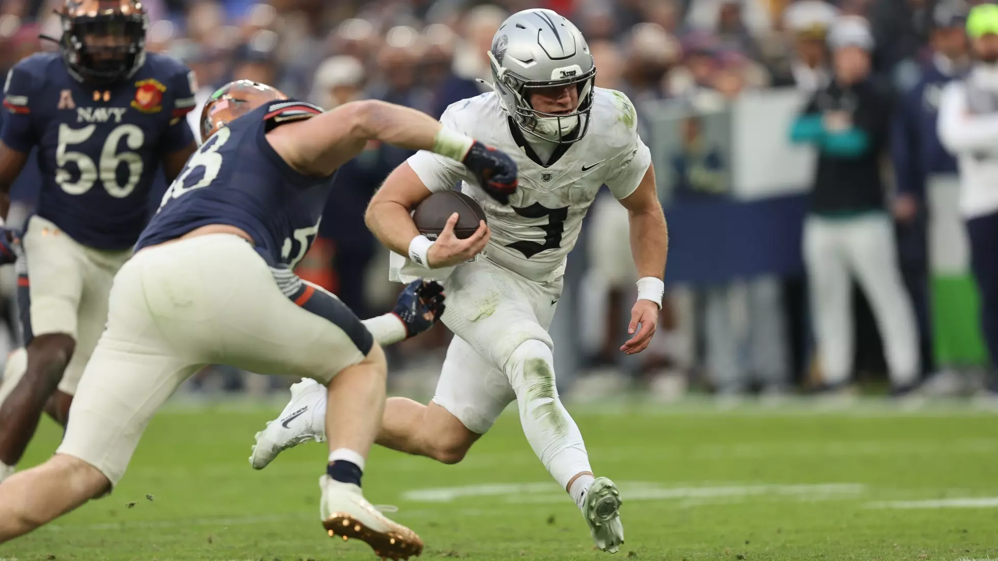 Army quarterback Cale Hellums runs with the football while evading a Navy defender during the 2025 Army-Navy Game.