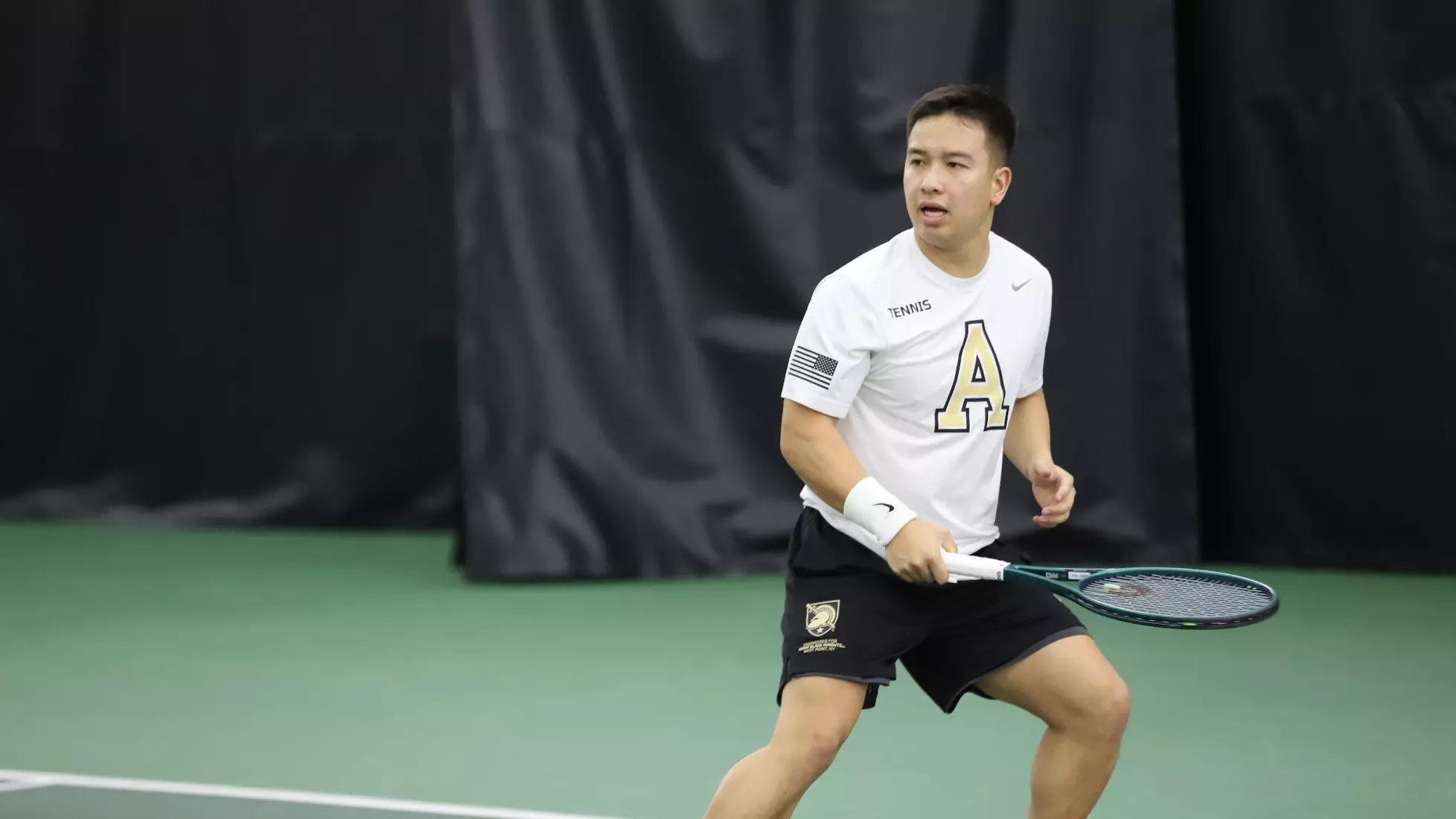 Army West Point men’s tennis player sets in a ready stance with his racquet during a match at the Lichtenberg Tennis Center.