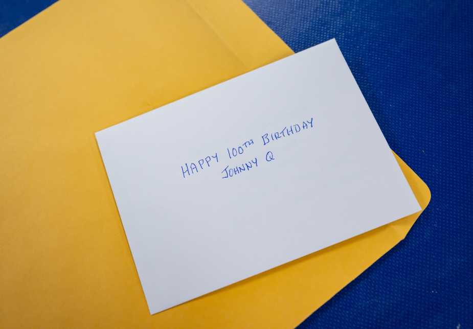 A handwritten note reading “Happy 100th Birthday Johnny Q” rests on an envelope on a table aboard the Battleship New Jersey Museum in Camden, N.J.