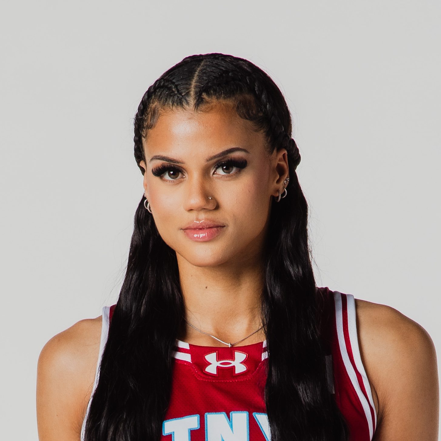 Headshot of Rae Burrell, Vinyl BC guard, wearing a maroon jersey with braided hair.