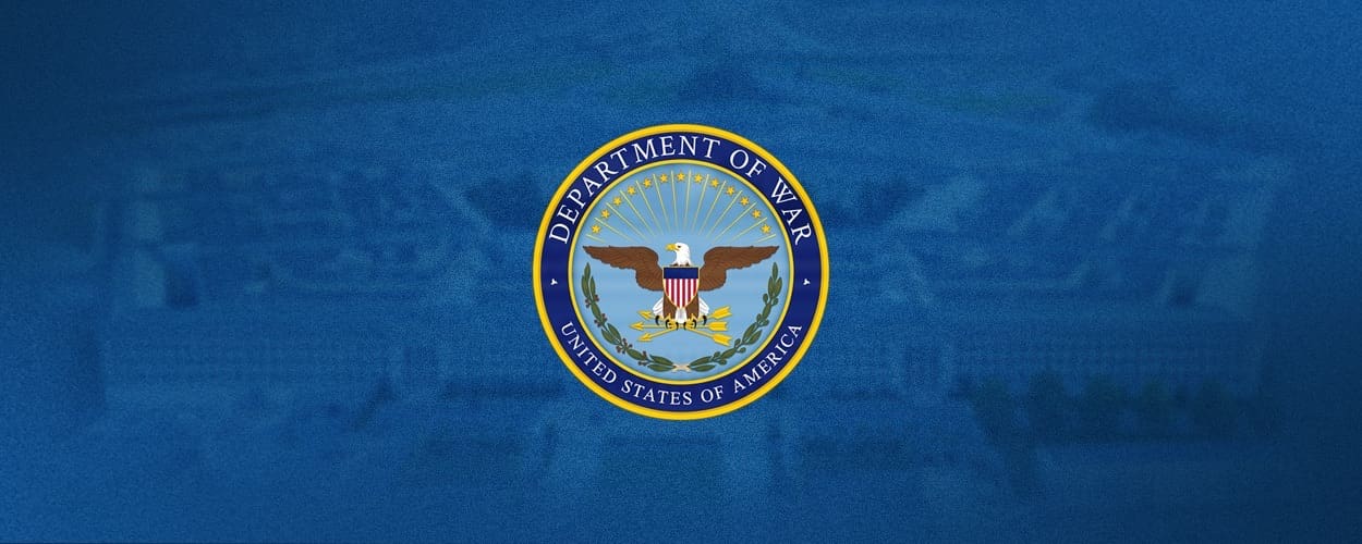 Department of War banner displayed on a wall, featuring the organization name and emblem.